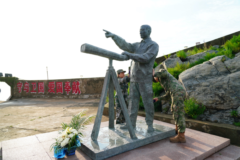 王仕花与开山岛民兵哨所所长陈志显一起擦拭王继才铜像(2023年7月27日摄)。李弘非 摄
