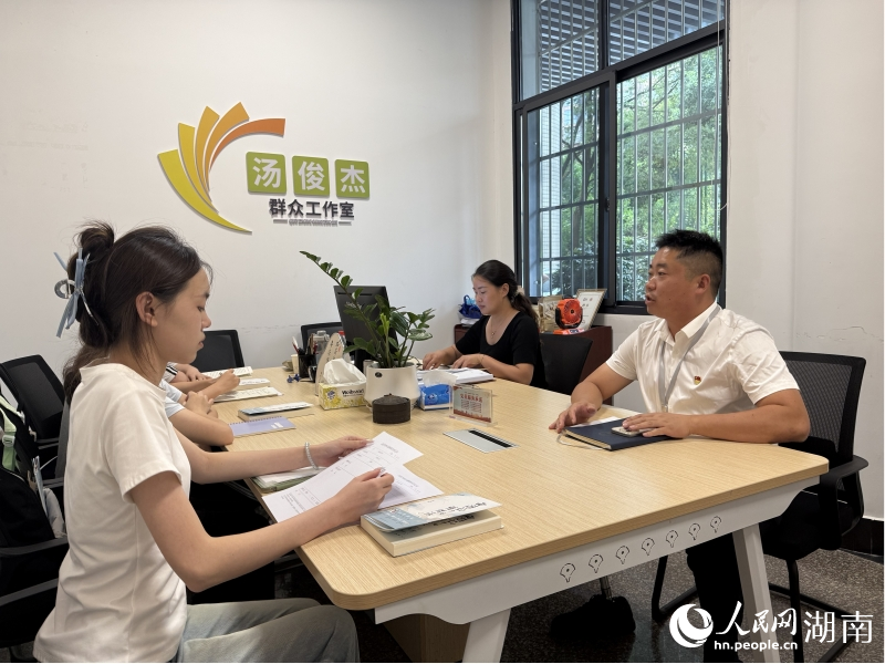 工作室里，汤俊杰（右一）正在商量当天的调解工作。人民网记者 刘汕摄